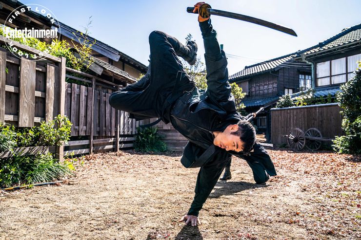 henry golding brandishes the sword morning light