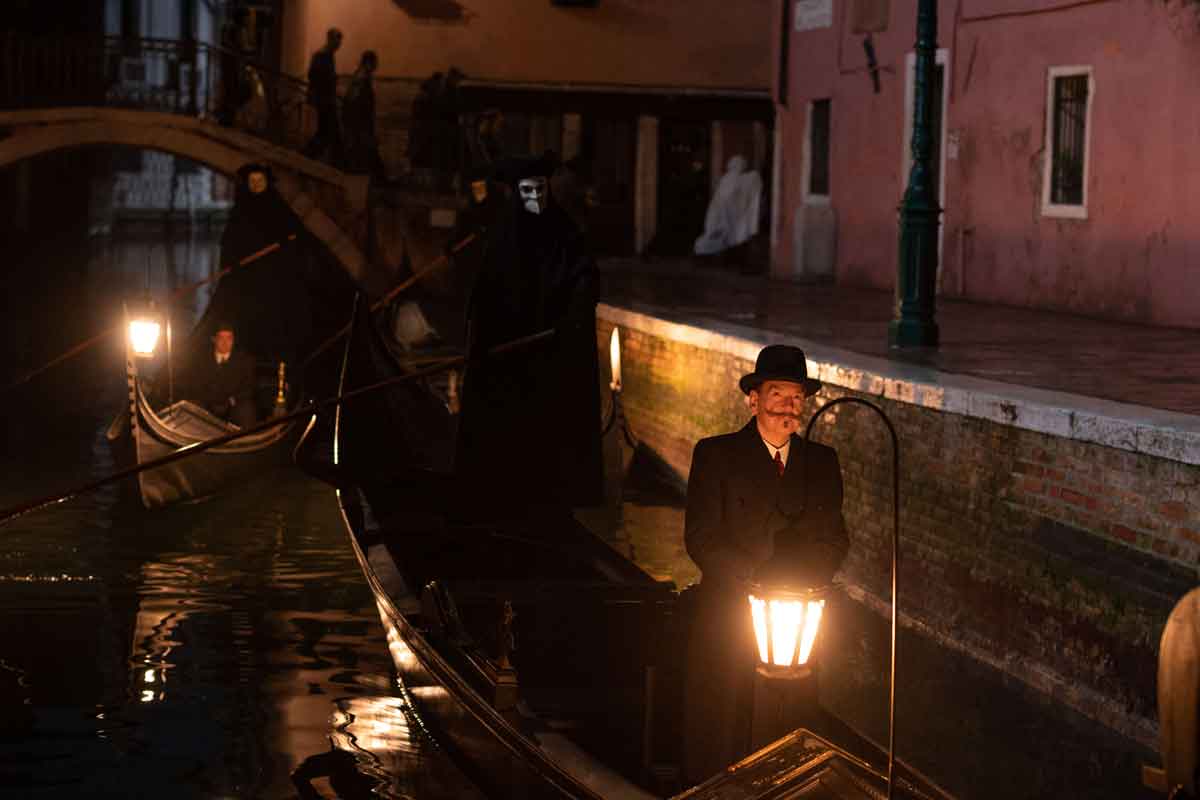 riccardo scamarcio as vitale portfoglio and kenneth branagh as hercule poirot in 20th century studios' a haunting in venice. 